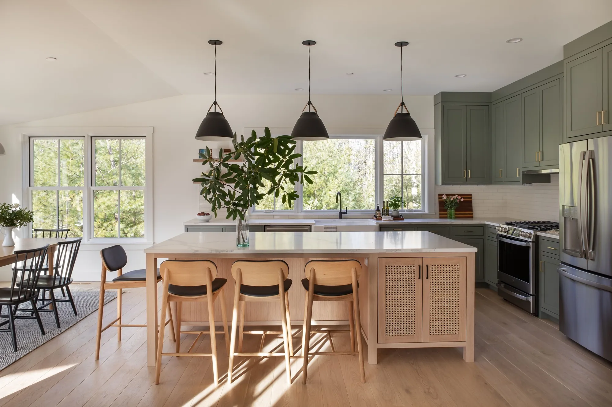 Wide-plank oak floor in a kitchen with sage cabinets