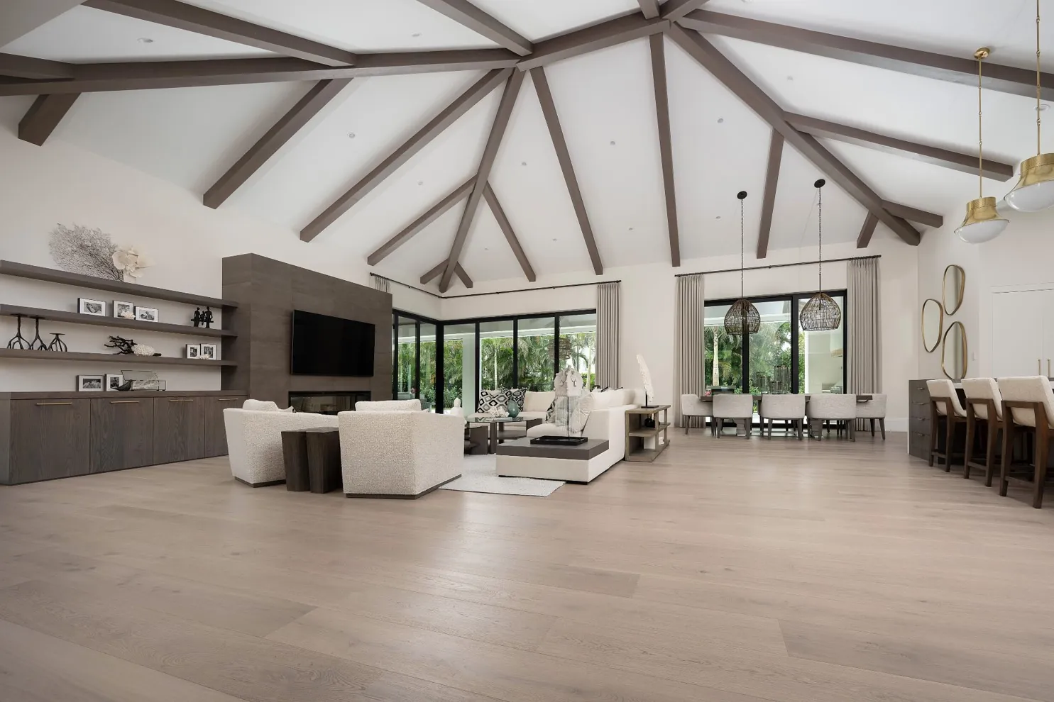 Wide-plank oak floor in a great room with a vaulted beamed ceiling