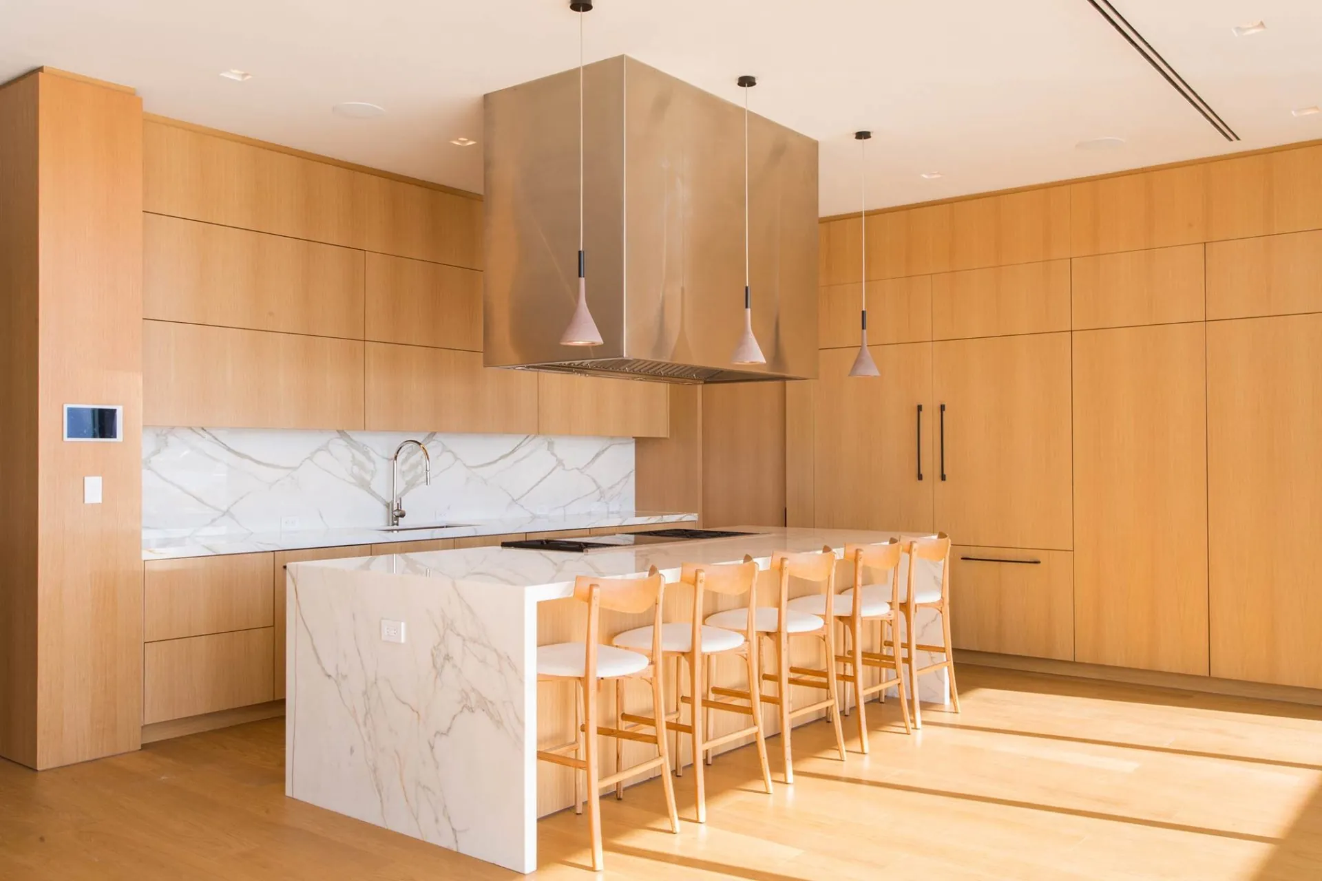 Wide-plank oak floor in a warm oak kitchen with a marble island