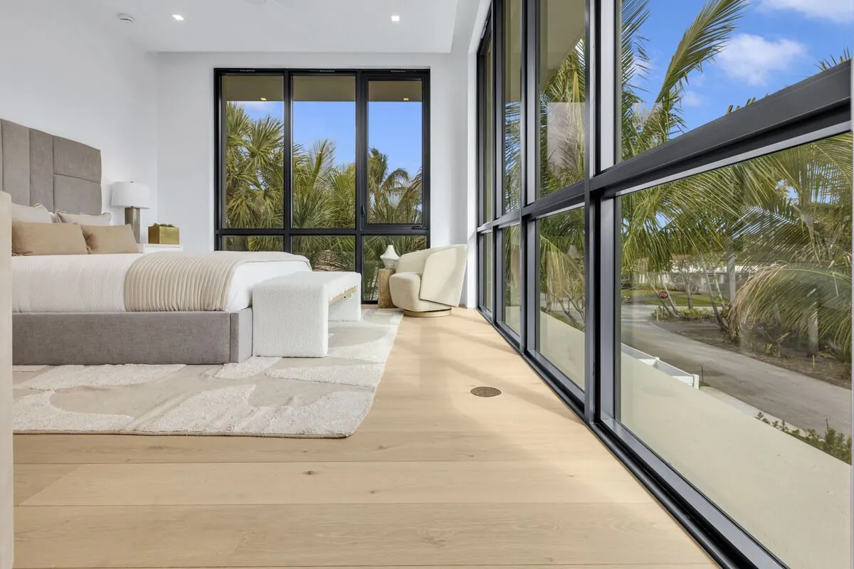 Wide-plank oak floor in a bright bedroom with a soft area rug