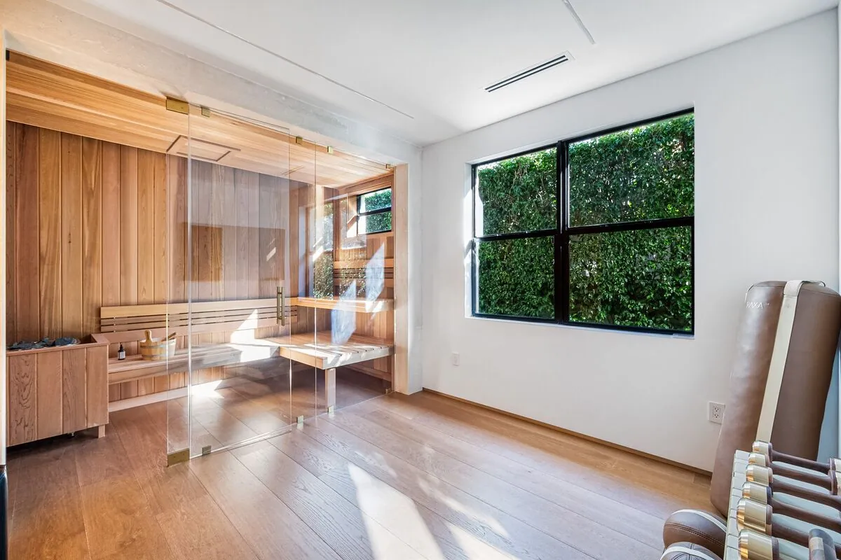Wide-plank oak floor in a room with a glass-walled cedar sauna